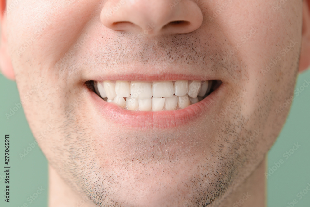 Fototapeta premium Man with healthy teeth on color background, closeup