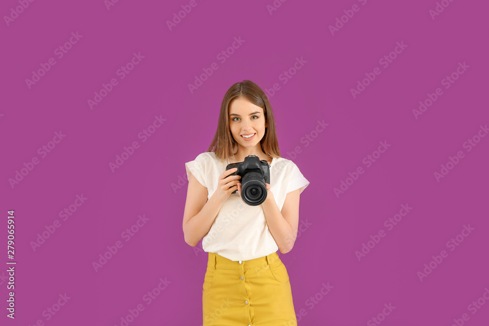 Obraz premium Young female photographer on color background