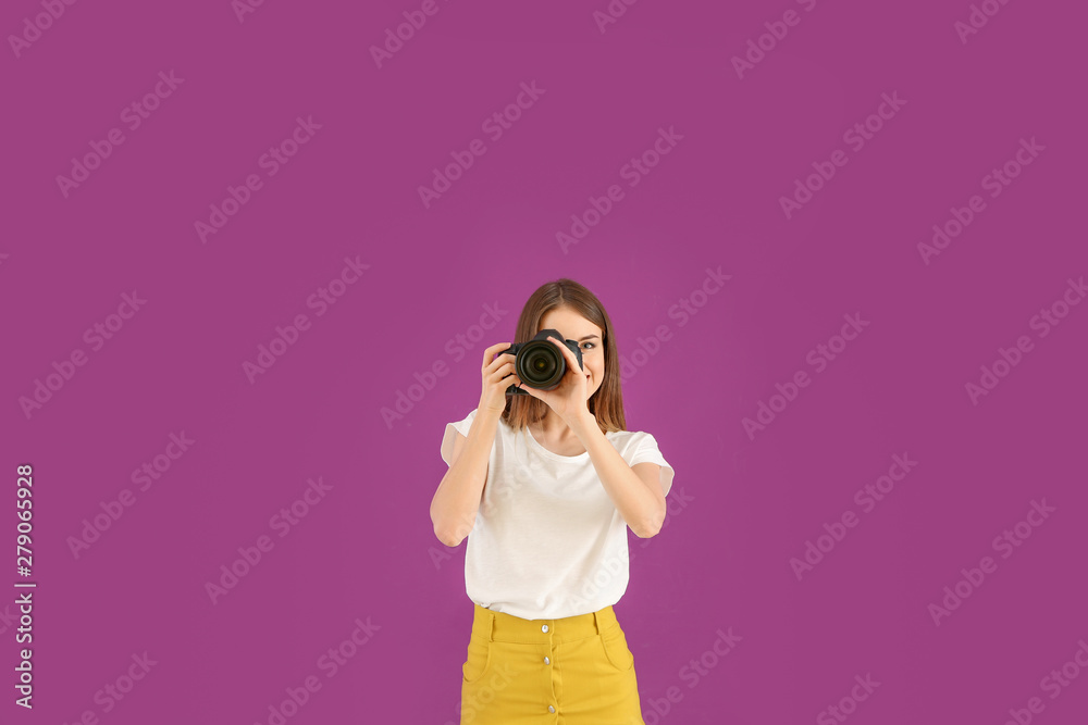 Young female photographer on color background Young female photographer on color background