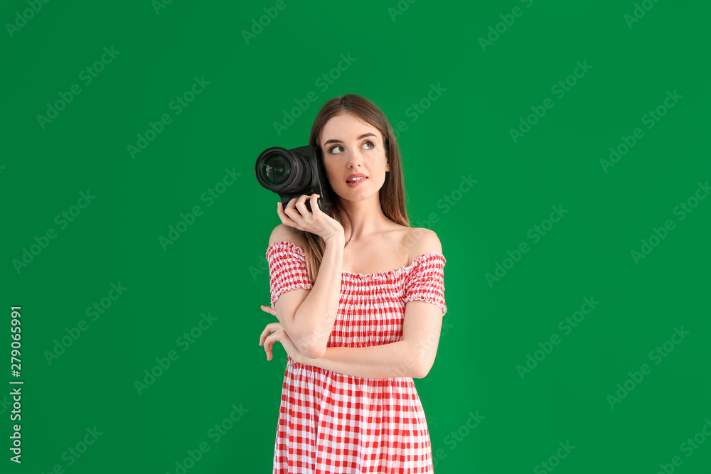 Obraz premium Young female photographer on color background