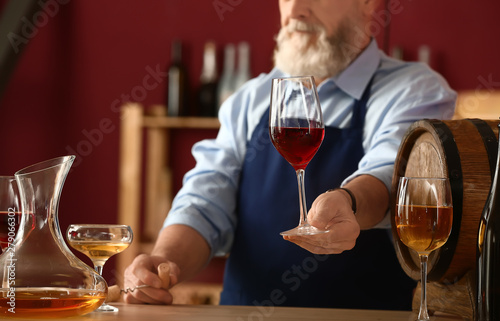 Mature sommelier working in...