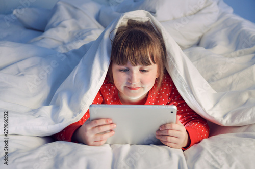 Cute little girl using tabl...