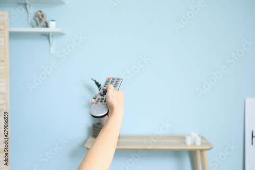 Young woman with TV remote control at home