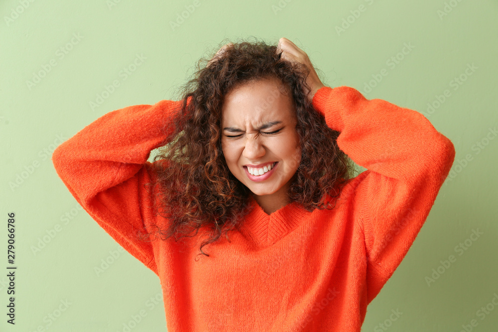 Stressed African-American woman on color background