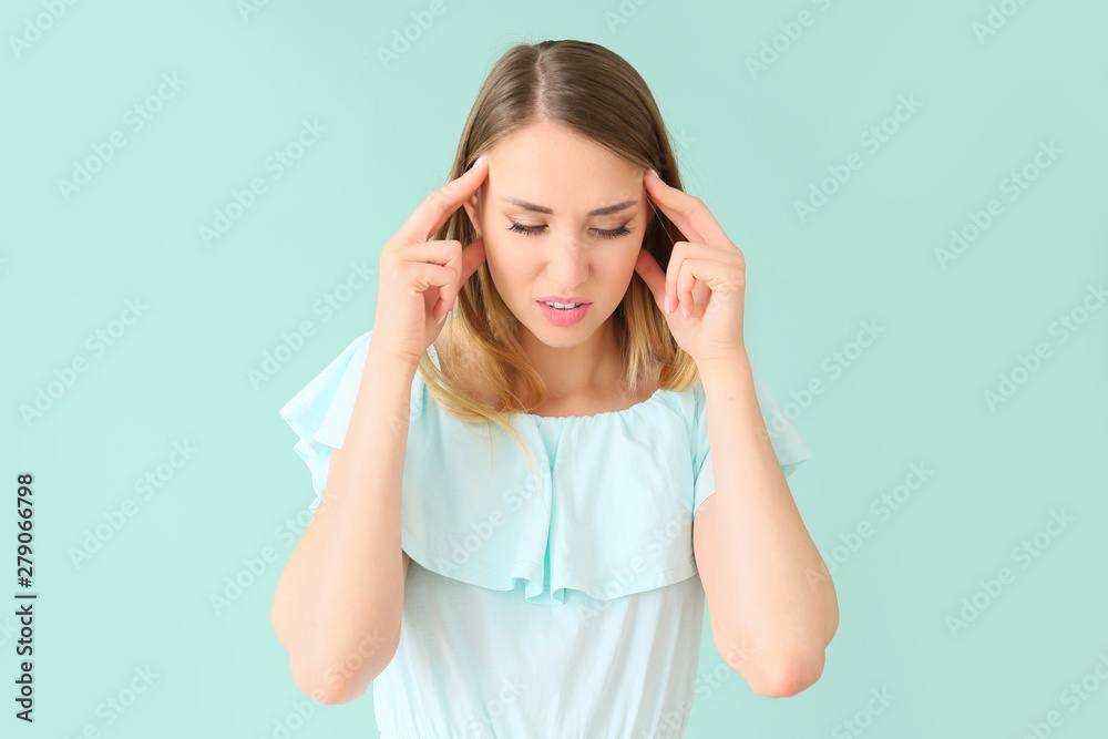 Young woman suffering from headache on color background Young woman suffering from headache on color background