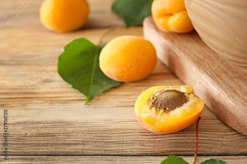 Tasty ripe apricots on wooden table