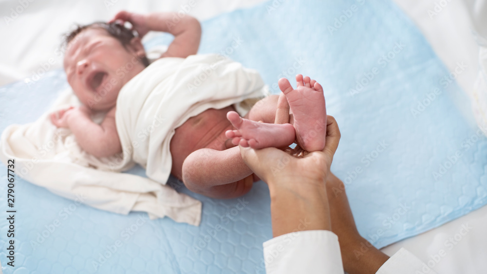 Beautiful newborn baby lying in his bed While crying on a white background. Beautiful newborn baby lying in his bed While crying on a white background.