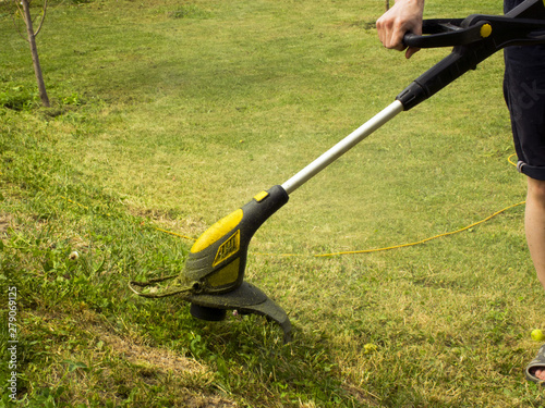 Trimmer for cutting the lawn. Grass shearing equipment. Garden technology.
