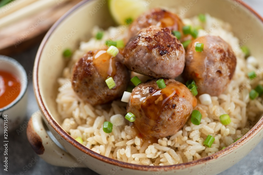 Close-up of roasted pork meatballs and rice in a bowl, selective focus