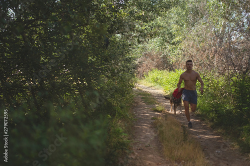 runner running across the field with his dog © robcartorres