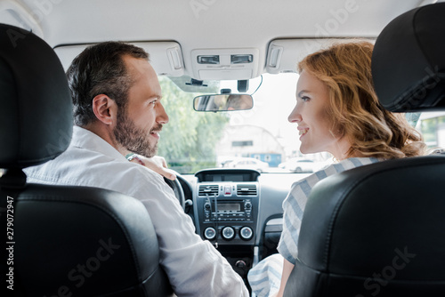 selective focus of happy man looking at cheerful woman in car © LIGHTFIELD STUDIOS