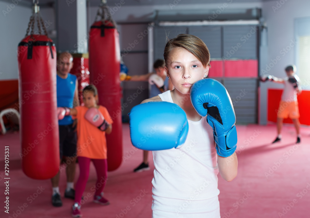 Teenage with boxing gloves posing in defended stance
