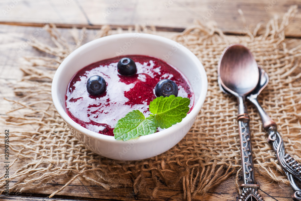 Blueberry jam in a plate and fresh blueberries on a wooden table. Blueberry jam in a plate and fresh blueberries on a wooden table.