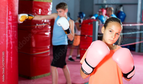 Girl with boxing gloves posing in defended stance