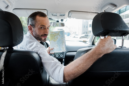 selective focus of bearded man sitting in car and holding map © LIGHTFIELD STUDIOS