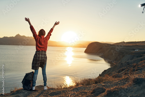 man with open arms raised at sunset