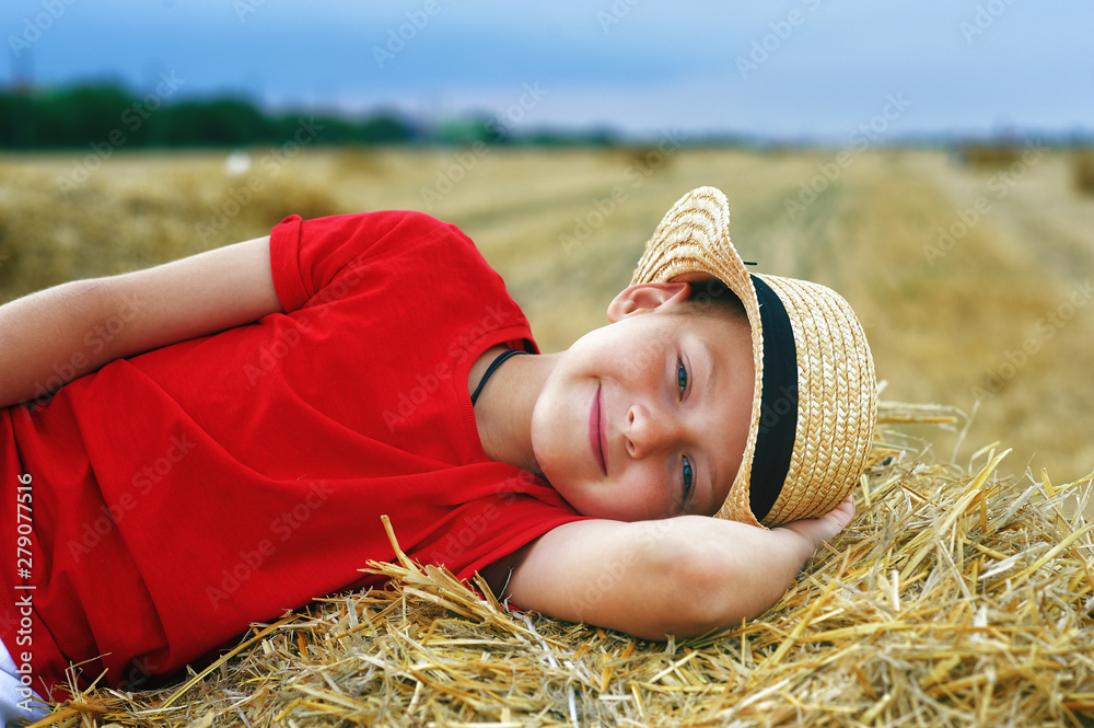 Portrait of a little boy on vacation in the field . The child lying in the manger Portrait of a little boy on vacation in the field . The child lying in the manger