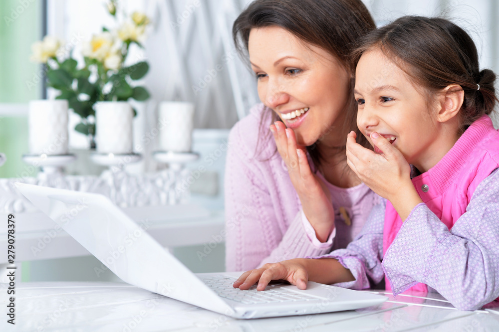 Portrait of happy mother and daughter using laptop together Portrait of happy mother and daughter using laptop together