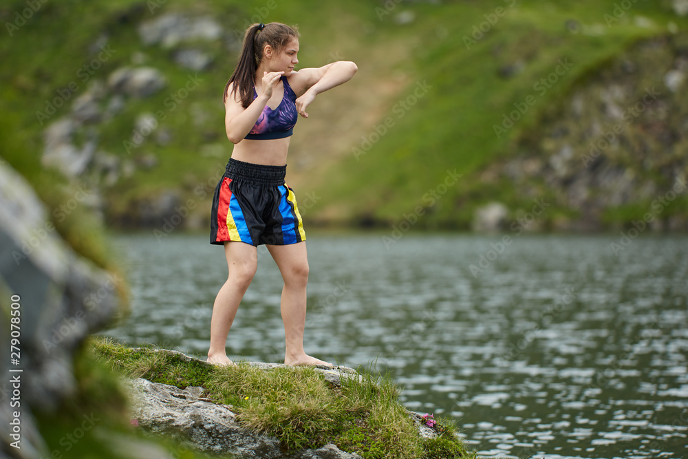 Woman kickbox fighter training by the lake Woman kickbox fighter training by the lake