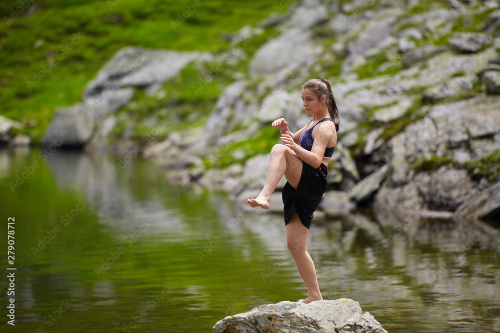 Fototapeta premium Woman kickbox fighter training by the lake