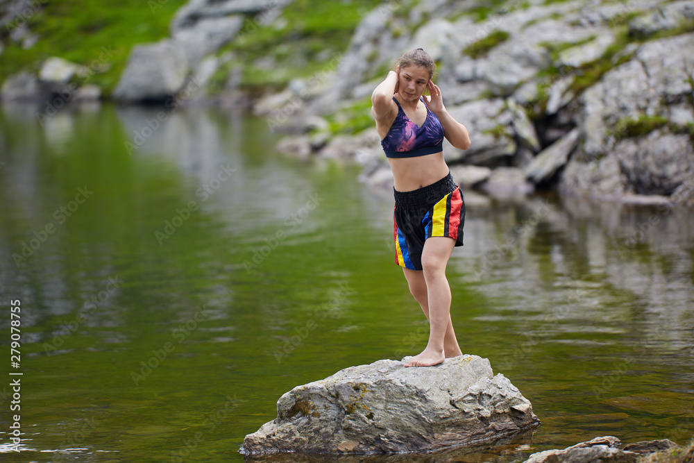 Woman kickbox fighter training by the lake Woman kickbox fighter training by the lake