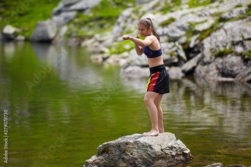 Woman kickbox fighter training by the lake