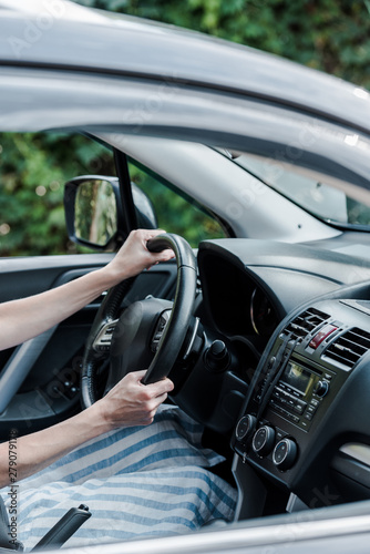 cropped view of woman driving car and holding steering wheel