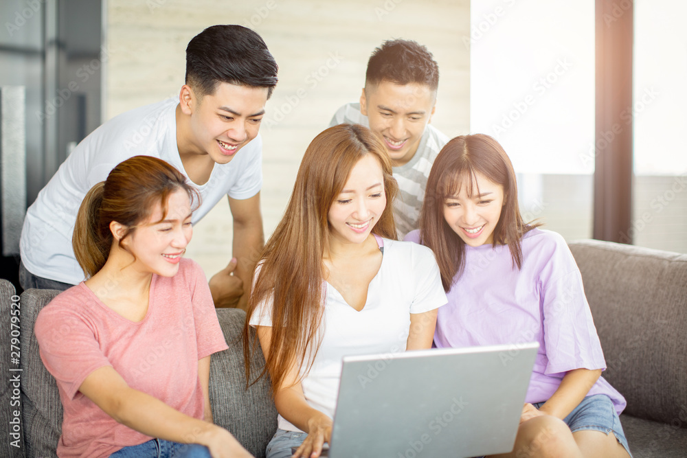 young people watching the laptop on the couch