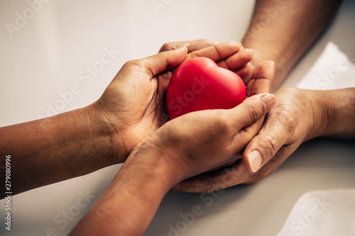 Helping hand of heart donor for patient in heart disease. Man give red heart to woman as couple. People lifestyle and couple romance. Healthcare and hospital medical concept. Symbolic of Valentine day