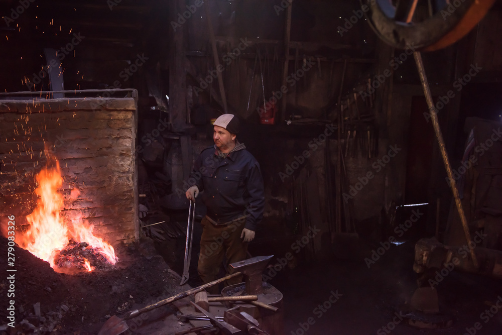 young traditional Blacksmith working with open fire young traditional Blacksmith working with open fire