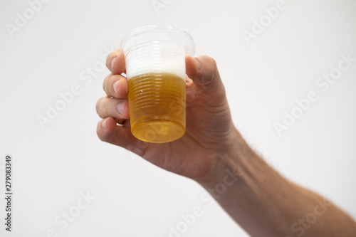 A closeup view on the arm and hand of a person enjoying a refreshing drink of lager. Toasting a drink, isolated against a clean white background.