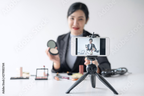 Business online on social media, Beautiful woman blogger is showing present tutorial beauty cosmetic product and broadcast live streaming video to social network while recording teaching online