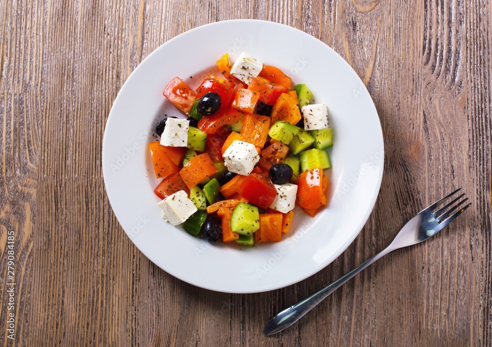 Greek salad of fresh cucumber, tomato, sweet pepper, feta cheese and olives with olive oil and spices. Healthy food, top view