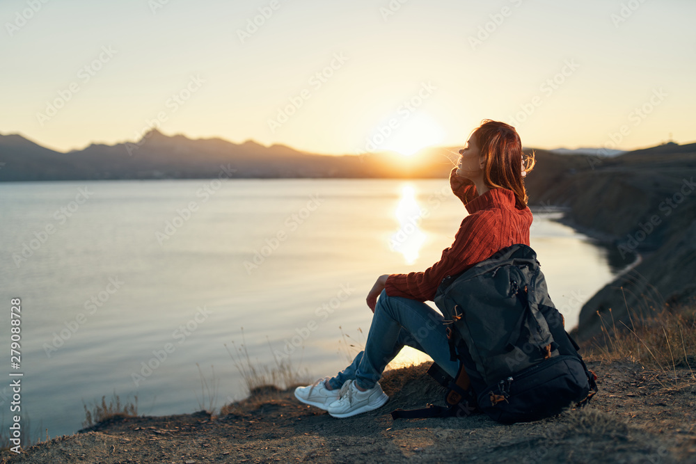 woman sitting on a rock at sunset