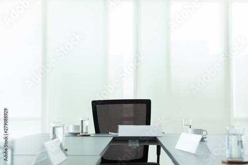 Modern Interior meeting room with evening sunset from clean glass windows, empty large conference space with chairs and tables furniture, business background