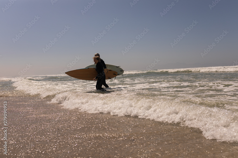 Senior surfer couple walking together at the beach Senior surfer couple walking together at the beach