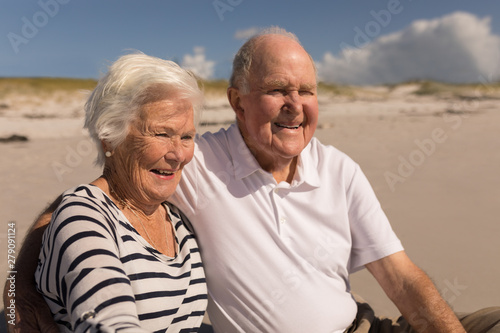 Happy senior couple sitting on beach