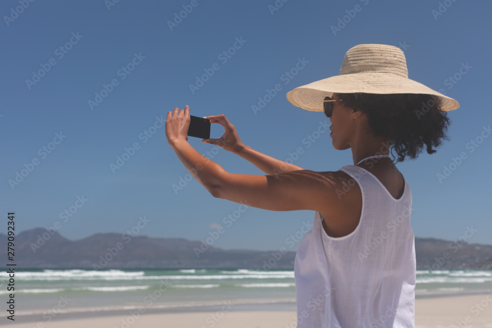 Fototapeta premium Young woman talking selfie at beach on sunny day