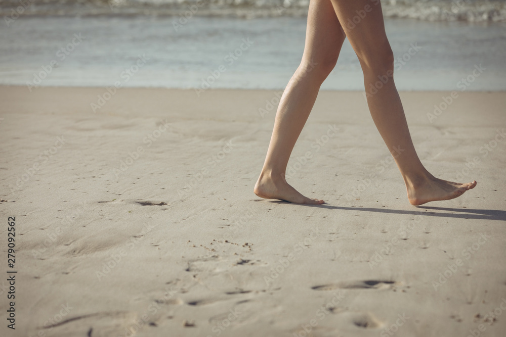 Woman walking on sand with barefoot at beach Woman walking on sand with barefoot at beach