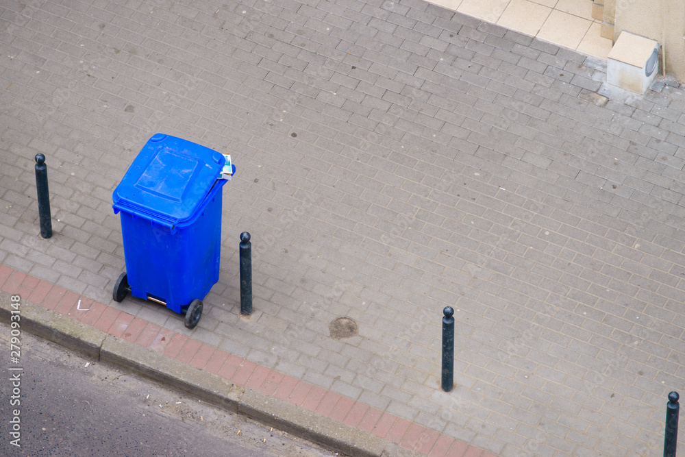 Naklejka premium Blue trash can on street pavement
