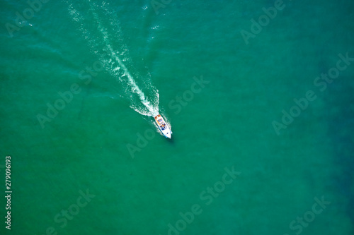 Yacht white blue awning on turquoise water, top view. Aerial photography with drone. 