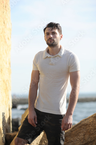 Young stylish man portrait dressed in white polo shirt and black shorts