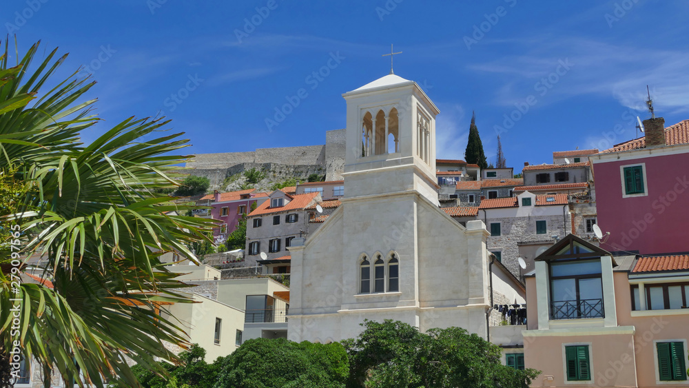Colourful historic city of Sibenik with palm trees and church, Croatia