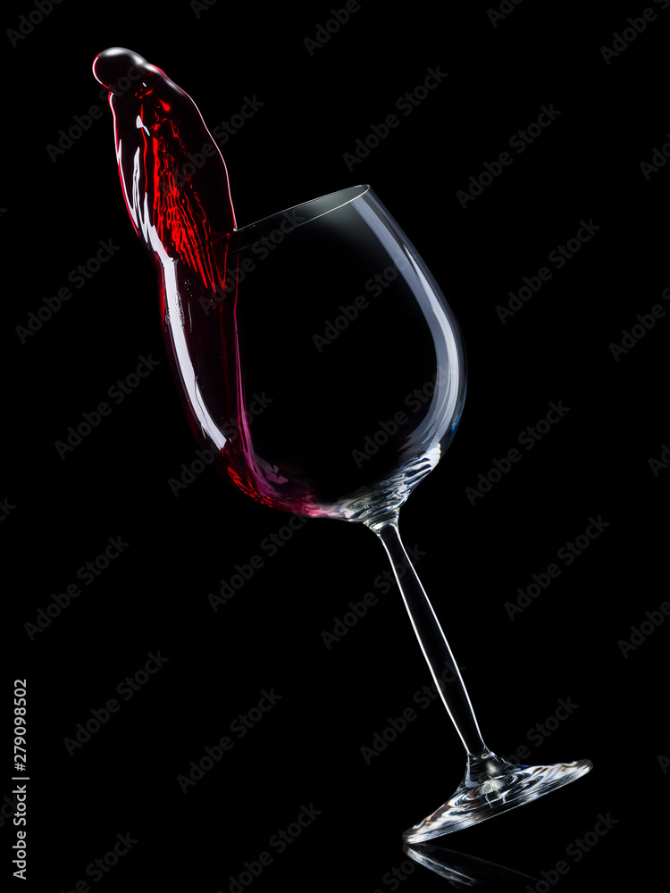 Glass for red wine with splashes isolated on black background. - obrazy, fototapety, plakaty 