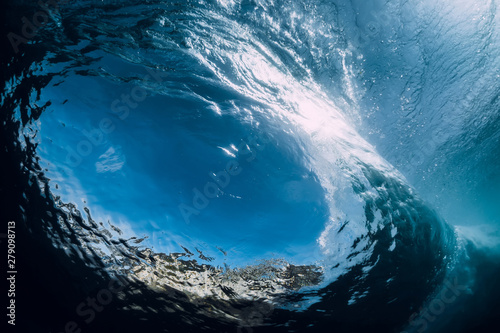 Barrel wave underwater with air bubbles and sun light. Ocean in underwater
