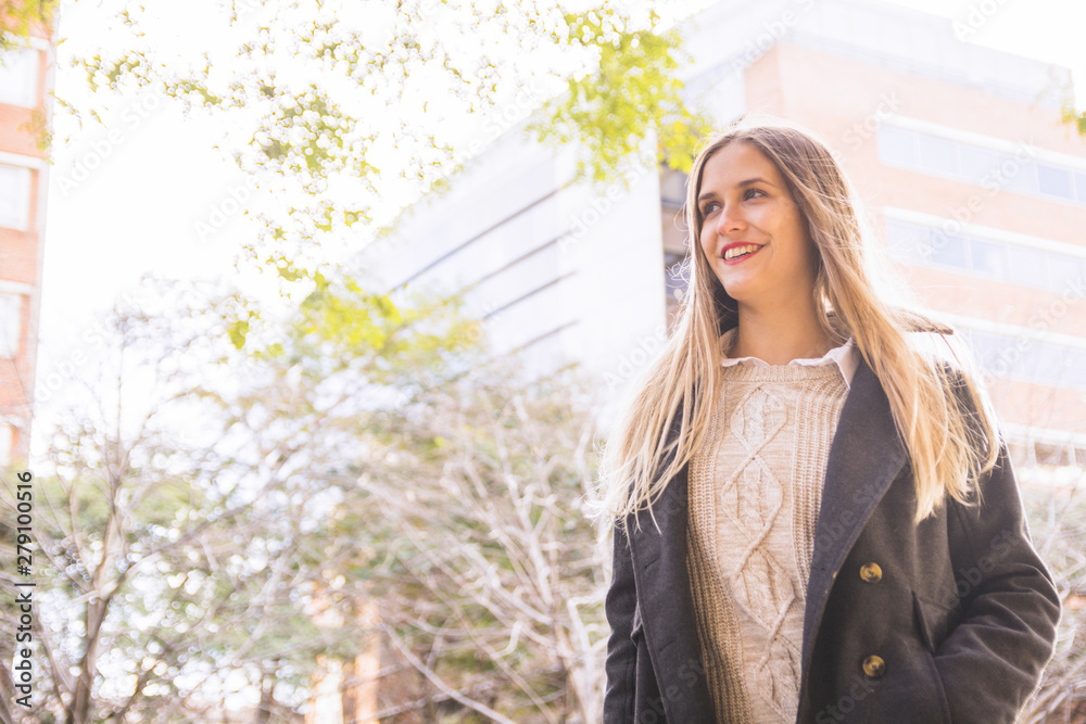 Naklejka premium Young woman model smiling at urban building shiny background