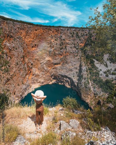 A young woman looking at the Red Lake in Imotski, Croatia