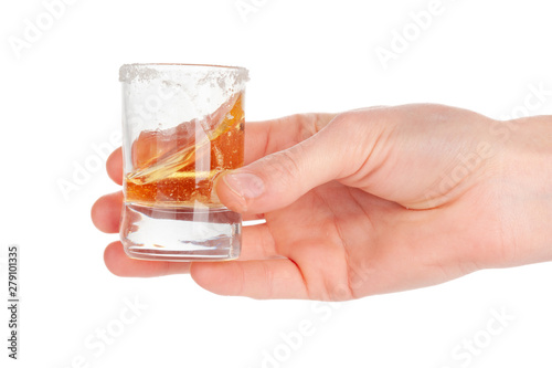 Man's hand holding a glass with tequila