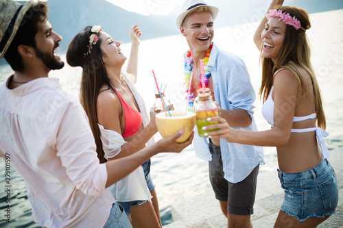 Group of friends having fun and dancing on the beach. Summer party on the beach