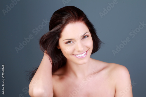 Portrait d'une jeune femme brune souriante en studio